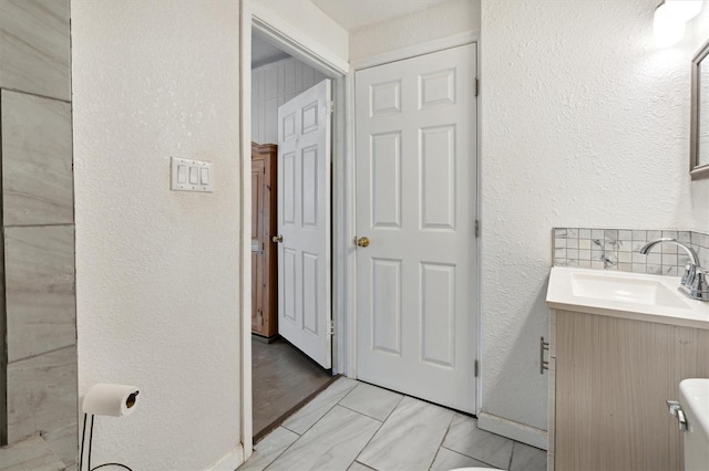 bathroom featuring vanity, toilet, and decorative backsplash