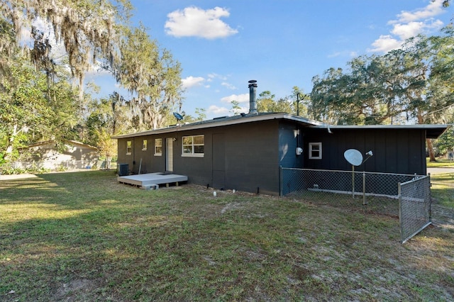 back of property with a lawn and central AC unit