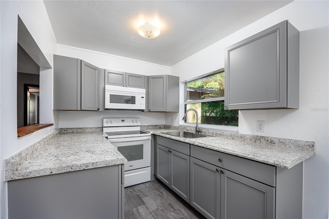 kitchen with gray cabinets, sink, and white appliances