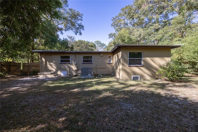 back of house featuring a yard and central AC