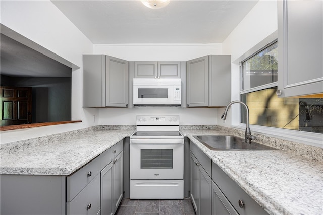 kitchen featuring white appliances, sink, and gray cabinetry