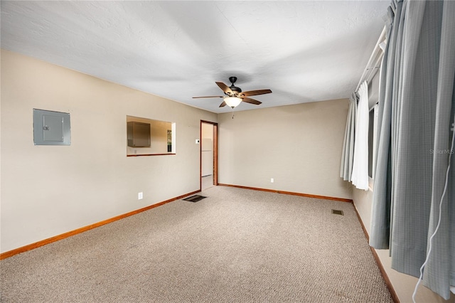 empty room with ceiling fan, electric panel, carpet, and a textured ceiling