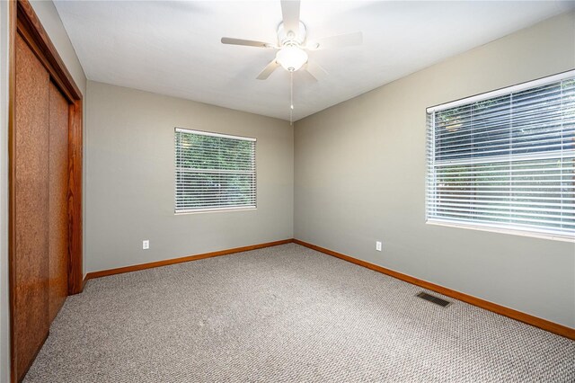 unfurnished bedroom featuring a closet, ceiling fan, and carpet flooring