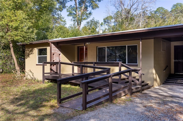 view of front facade with concrete block siding and a deck