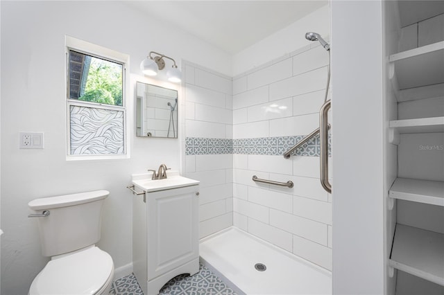 full bathroom with toilet, a tile shower, and vanity