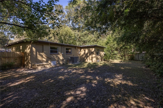 back of house with fence and central AC unit