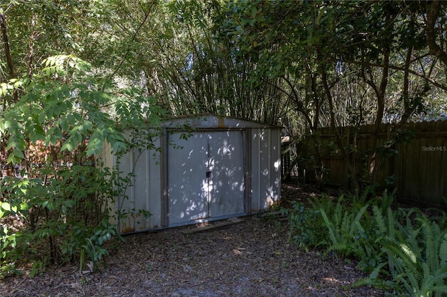 view of shed featuring fence