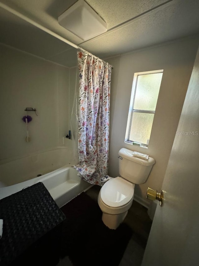 bathroom featuring shower / bathtub combination with curtain and toilet