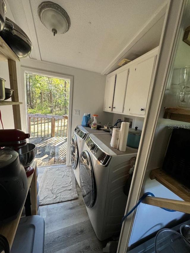 laundry room with hardwood / wood-style floors, cabinets, independent washer and dryer, and a textured ceiling