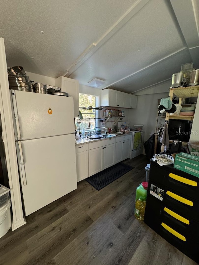 kitchen featuring vaulted ceiling, dark hardwood / wood-style flooring, white cabinets, and white appliances