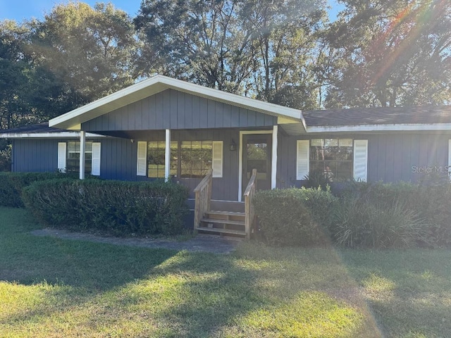 ranch-style home with a porch and a front lawn