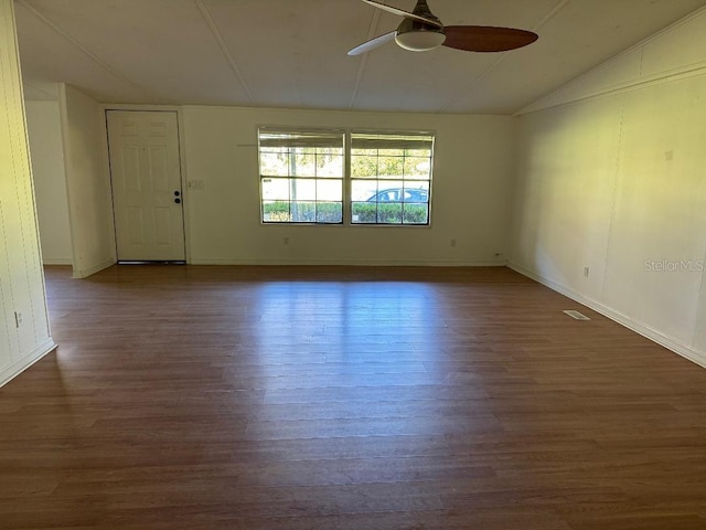 empty room featuring ceiling fan, dark hardwood / wood-style flooring, and vaulted ceiling