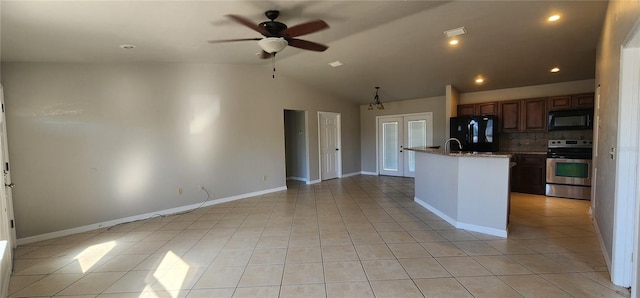 kitchen with lofted ceiling, a kitchen island with sink, black appliances, ceiling fan with notable chandelier, and light stone countertops