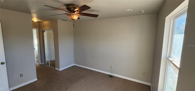 carpeted spare room featuring ceiling fan