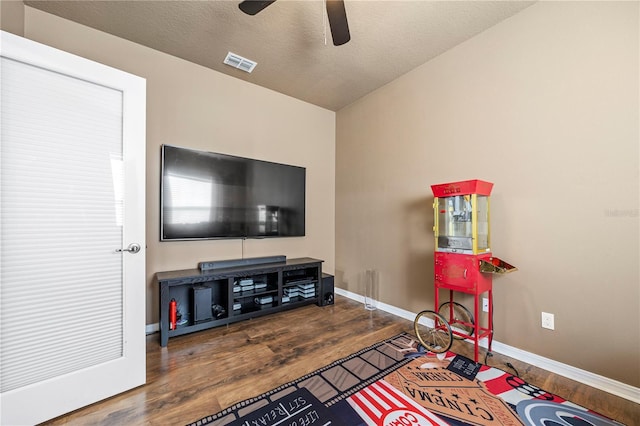 living room featuring a textured ceiling, dark hardwood / wood-style flooring, ceiling fan, and lofted ceiling