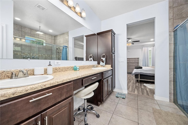 bathroom featuring ceiling fan, walk in shower, tile patterned flooring, a textured ceiling, and vanity