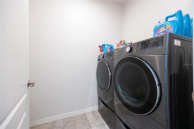 laundry room with washing machine and clothes dryer and light tile patterned flooring