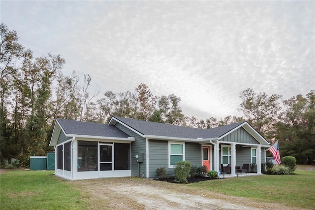 view of front of house featuring a sunroom and a front yard