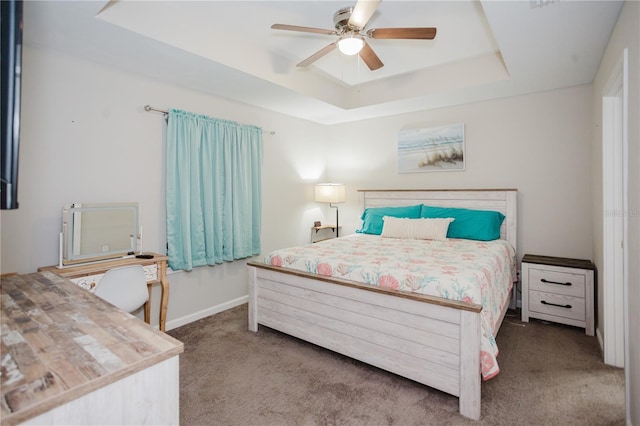 bedroom featuring a raised ceiling, ceiling fan, and carpet flooring