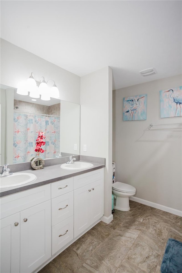 bathroom featuring a shower with shower curtain, vanity, and toilet