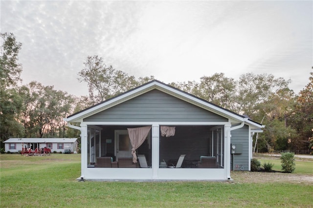 rear view of house with a sunroom and a yard