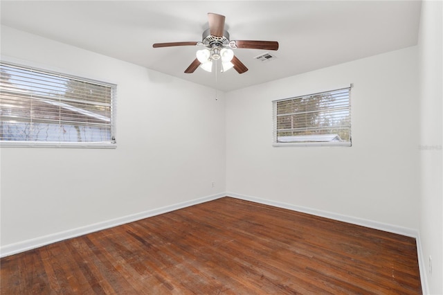 spare room with dark hardwood / wood-style floors and ceiling fan