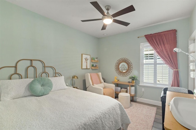 bedroom with ceiling fan, hardwood / wood-style floors, and sink