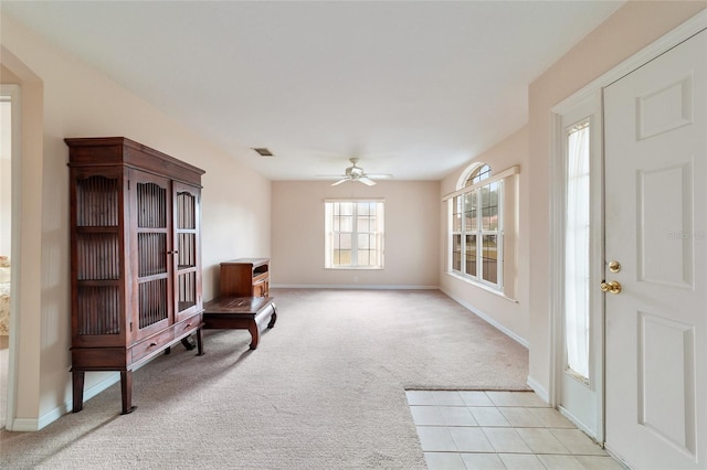 living area with ceiling fan and light carpet