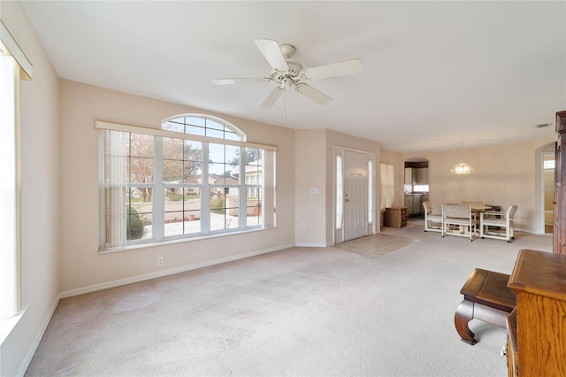 unfurnished living room featuring light carpet and ceiling fan