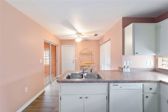 kitchen featuring white dishwasher, dark hardwood / wood-style flooring, sink, and a wealth of natural light