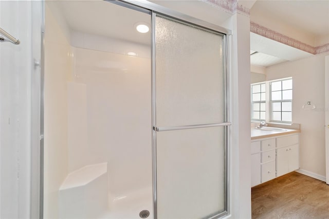 bathroom featuring vanity, a shower with shower door, and hardwood / wood-style flooring