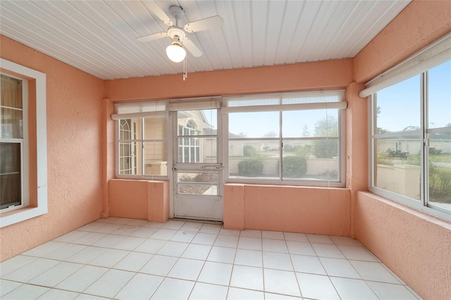 unfurnished sunroom featuring a wealth of natural light, wooden ceiling, and ceiling fan