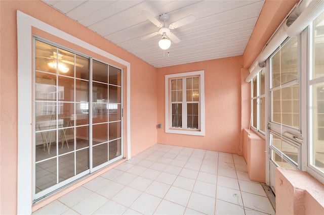 unfurnished sunroom featuring ceiling fan