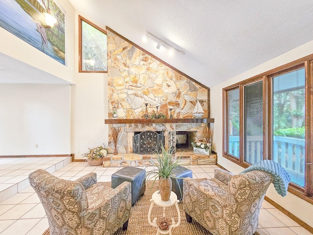 tiled living room featuring a fireplace, rail lighting, a textured ceiling, and vaulted ceiling