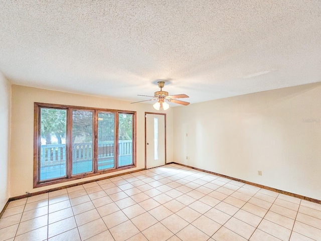 tiled spare room with a textured ceiling and ceiling fan