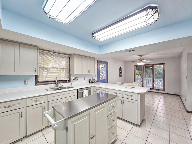 kitchen featuring a kitchen island, sink, stainless steel dishwasher, and kitchen peninsula