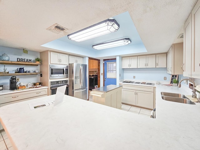 kitchen with sink, stainless steel appliances, a center island, and light tile patterned flooring