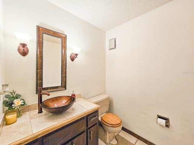 bathroom featuring vanity, toilet, and a textured ceiling