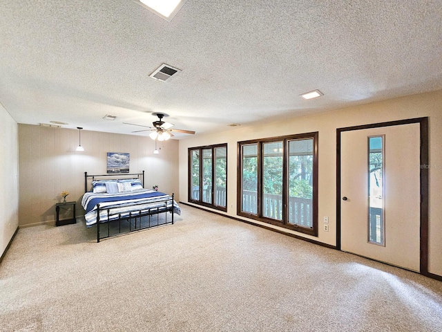 carpeted bedroom featuring ceiling fan and a textured ceiling