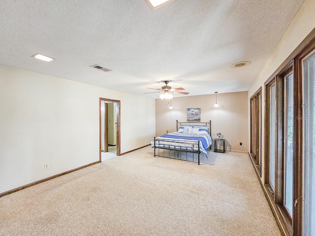 bedroom with ceiling fan, light carpet, and a textured ceiling