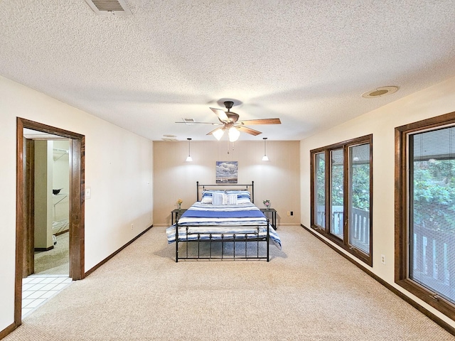 bedroom with ceiling fan, light carpet, and a textured ceiling