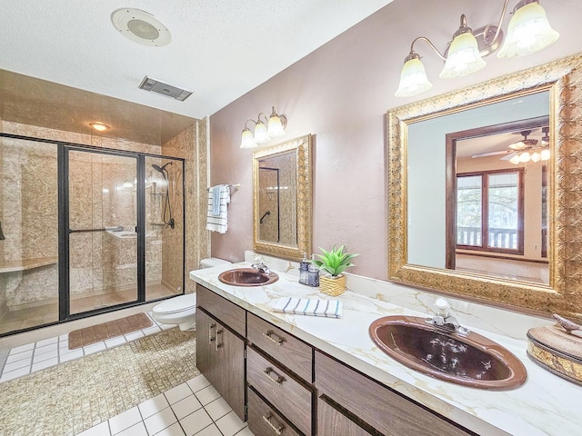 bathroom with tile patterned flooring, vanity, walk in shower, toilet, and a textured ceiling