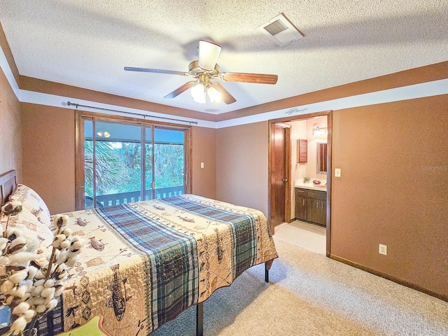 bedroom with connected bathroom, ceiling fan, light colored carpet, and a textured ceiling