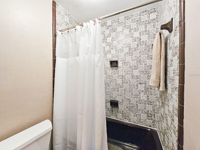 bathroom with a shower with shower curtain, a textured ceiling, and toilet