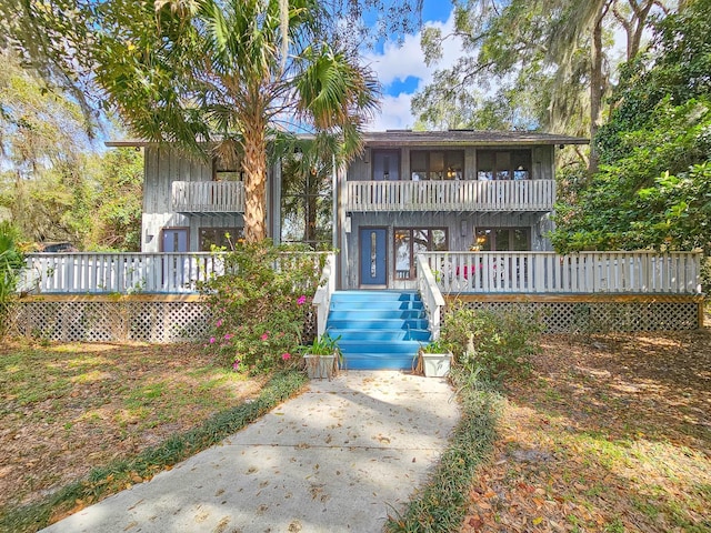 back of property with a wooden deck and a balcony