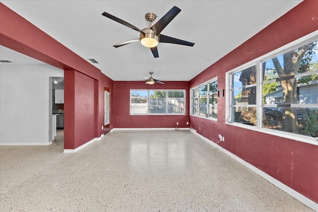 unfurnished sunroom with ceiling fan