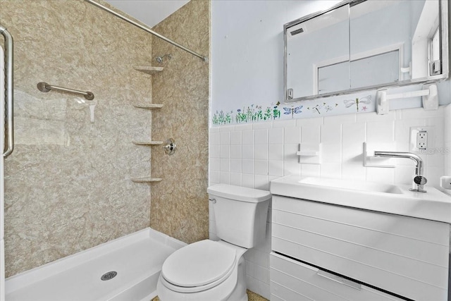 bathroom with tiled shower, vanity, tile walls, and toilet