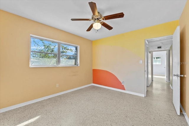 unfurnished room featuring ceiling fan and plenty of natural light