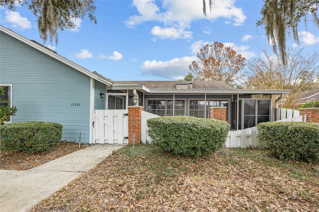 rear view of property featuring a sunroom