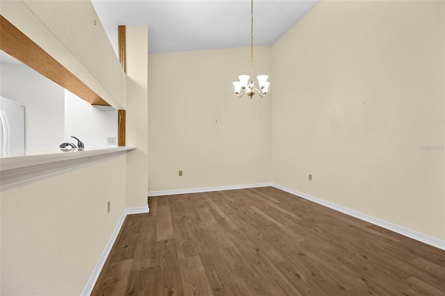 unfurnished dining area featuring hardwood / wood-style floors, sink, and an inviting chandelier